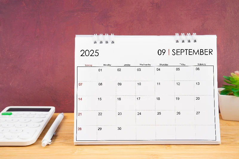 September 2025 white calendar and calculator with pen
