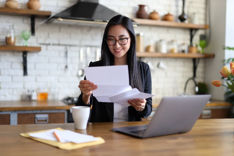 Businesswoman happily read a finance letter at her desk